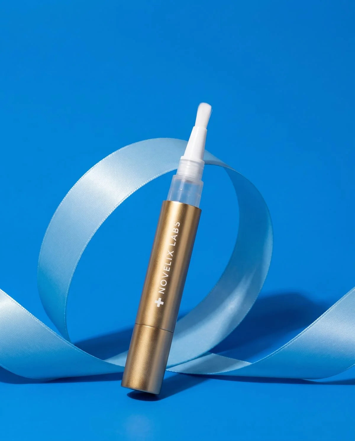 Gold Pen whitening product with blue ribbon